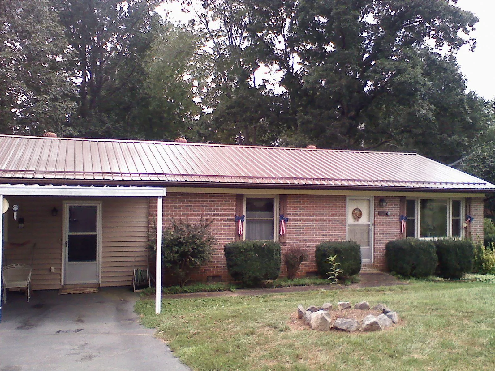 Bronze metal roof and carport on a brick ranch home — Roof Repair work by our crew in Central City